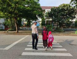Personel Sat Lantas Polres Bima Kota Bantu Anak Sekolah Menyeberang Jalan